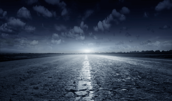 An empty road at night under a bright sky, offering a serene and mysterious atmosphere.
