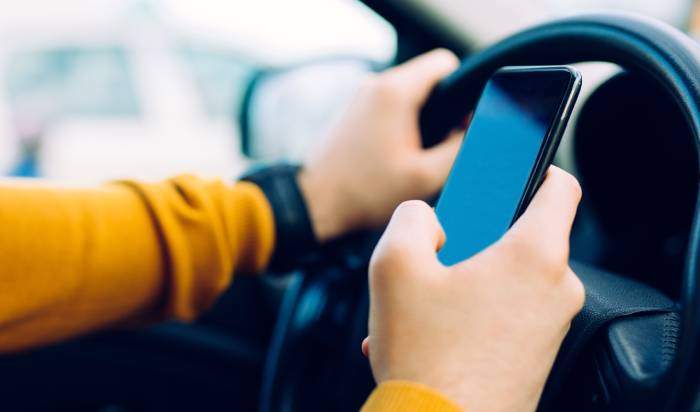 A person holding a phone while driving.