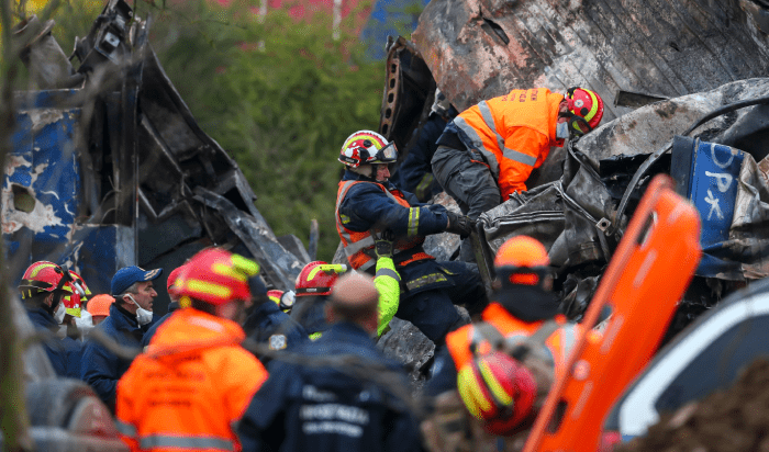 A team of workers in orange vests diligently clearing debris from a pile of crushed .