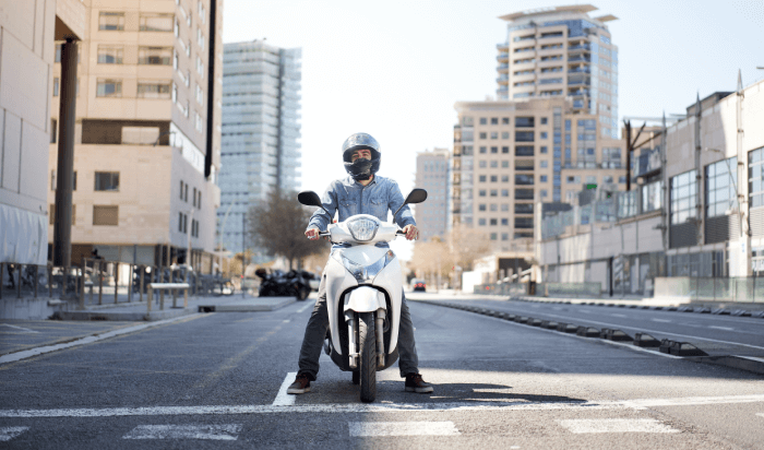 A motorcyclist navigating through a bustling city street.
