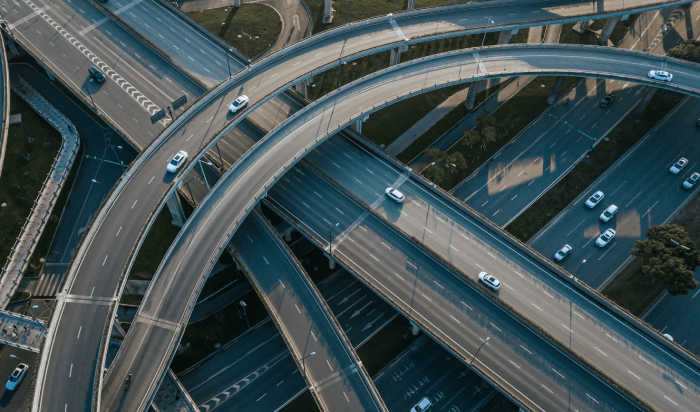 Aerial view of a busy highway intersection, showcasing the intricate network of roads and the bustling traffic below.